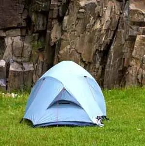 To select the best campsite, avoid high winds and set up your tent behind large boulders or heavy forest.