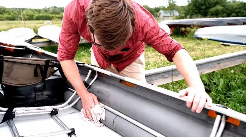 vecteezy_a-man-diligently-wipes-the-kayak-from-water-drops-after-a_17669440