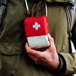 vecteezy_a-tourist-person-holds-in-his-hand-a-first-aid-kit-a-red_40506636