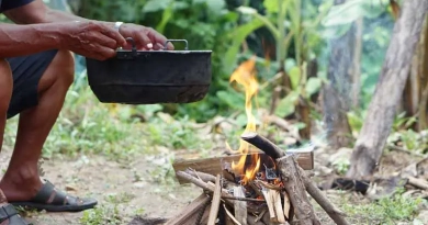 vecteezy_close-up-man-holds-old-black-pot-to-cook-on-bonfire_33368347