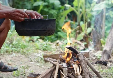 vecteezy_close-up-man-holds-old-black-pot-to-cook-on-bonfire_33368347