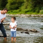 vecteezy_father-teaching-son-how-to-fly-fish-in-river_42589441