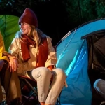 vecteezy_group-of-people-are-sitting-in-front-of-a-tent-camping-in_46699637