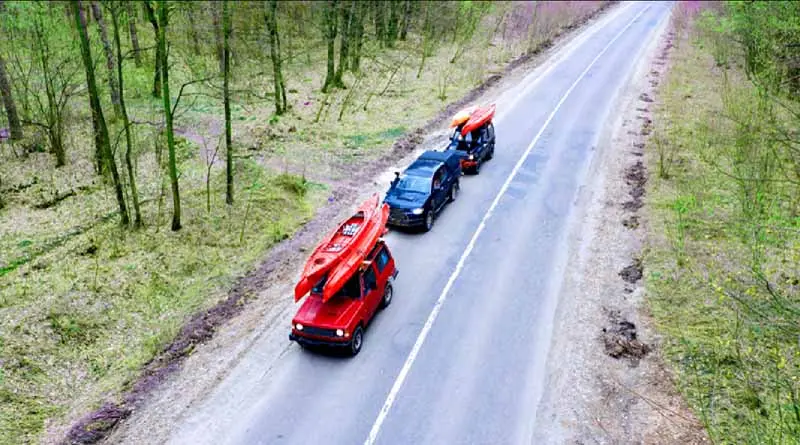 vecteezy_several-cars-with-kayaks-on-roof-rack-driving-on-the-road_11444494