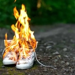 vecteezy_used-white-high-sneakers-burning-on-a-rural-road-that-runs_41506153