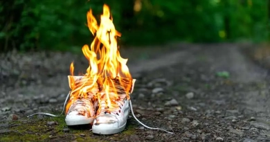 vecteezy_used-white-high-sneakers-burning-on-a-rural-road-that-runs_41506153