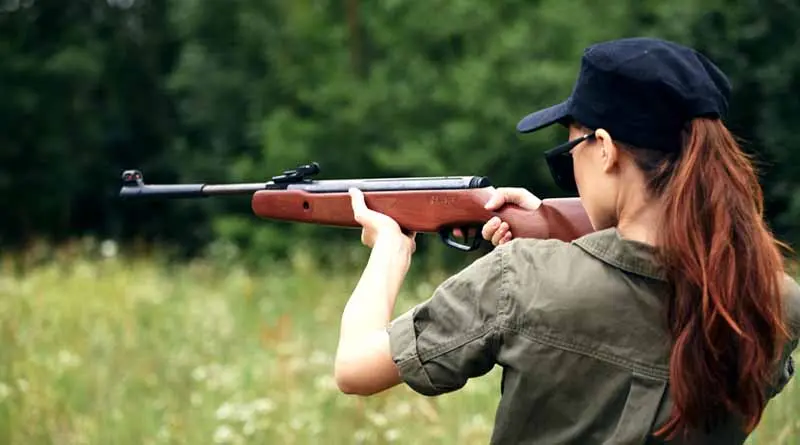 vecteezy_woman-holds-aiming-hunting-green-overalls_22004738