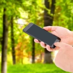 vecteezy_hand-hold-phone-and-touch-screen-on-blurred-park-background_3737348