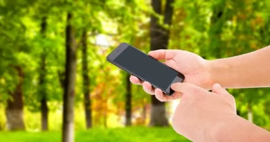 vecteezy_hand-hold-phone-and-touch-screen-on-blurred-park-background_3737348